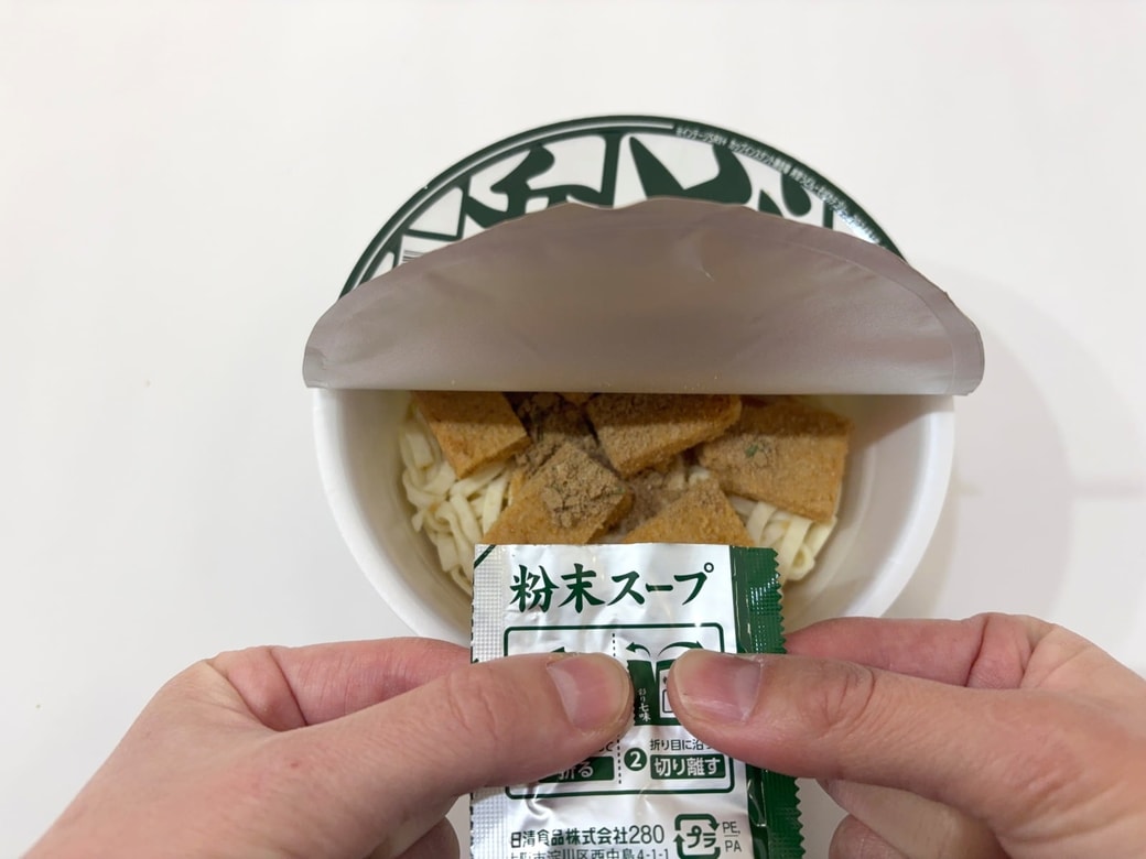 お揚げを切って粉末スープを半袋入れる