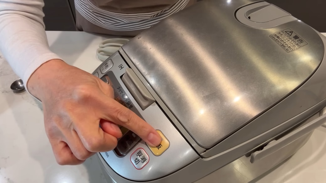 炊飯器のスイッチを押す人