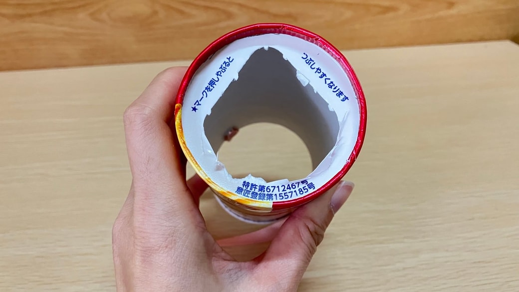 底に穴をあけたチップスターの箱