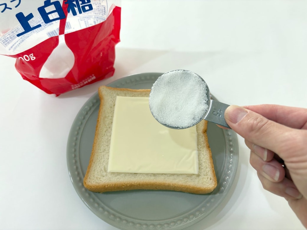 食パンにスライスチーズをのせて砂糖をかける