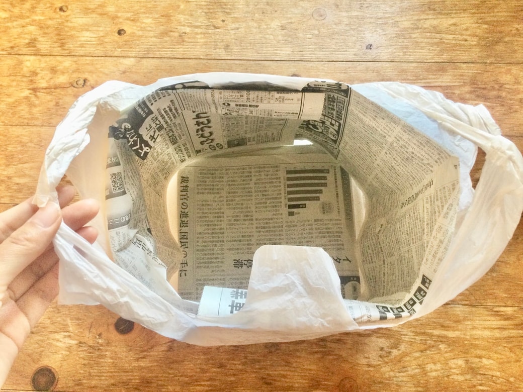 ゴミ袋の中に新聞紙を入れる