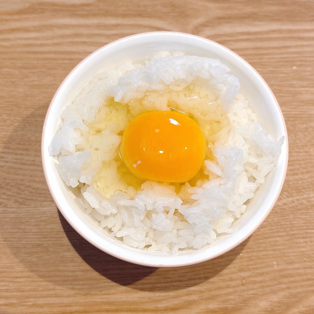 ごはんの真ん中に卵を割り入れる