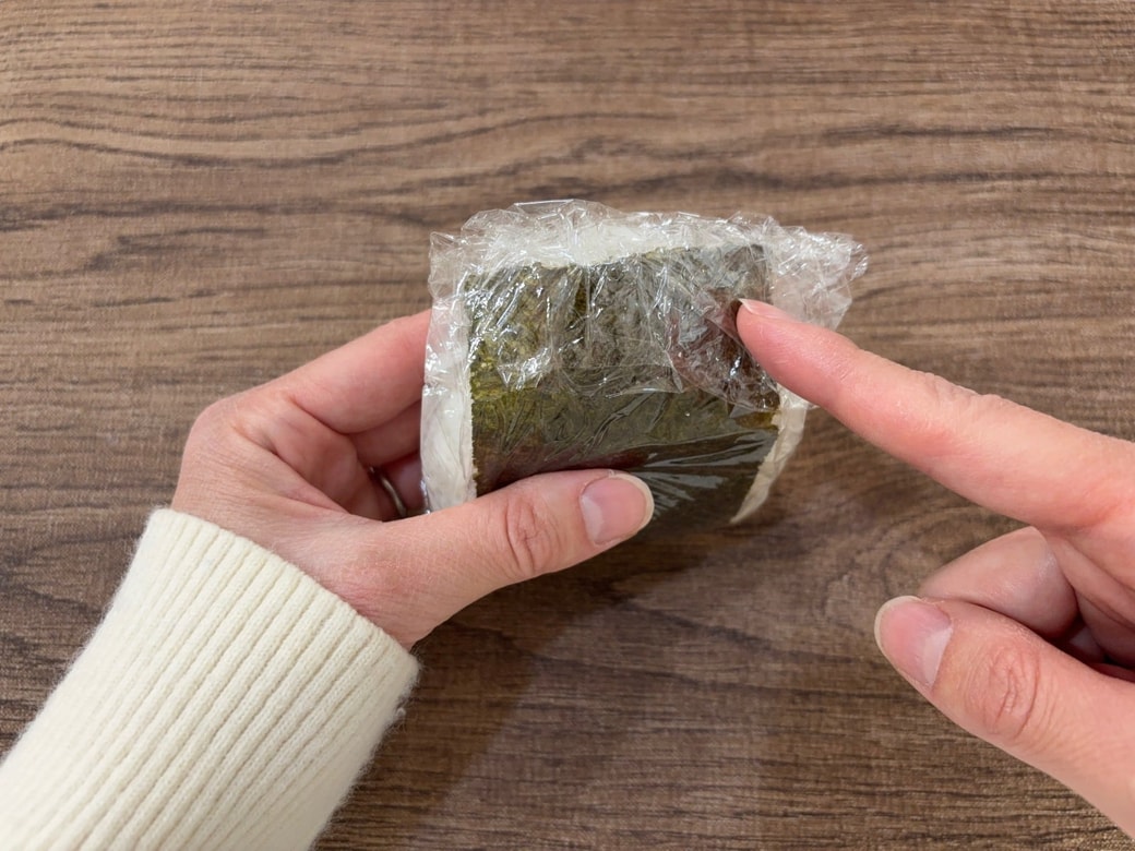 おにぎりを包み、上の余っているラップをたたむ