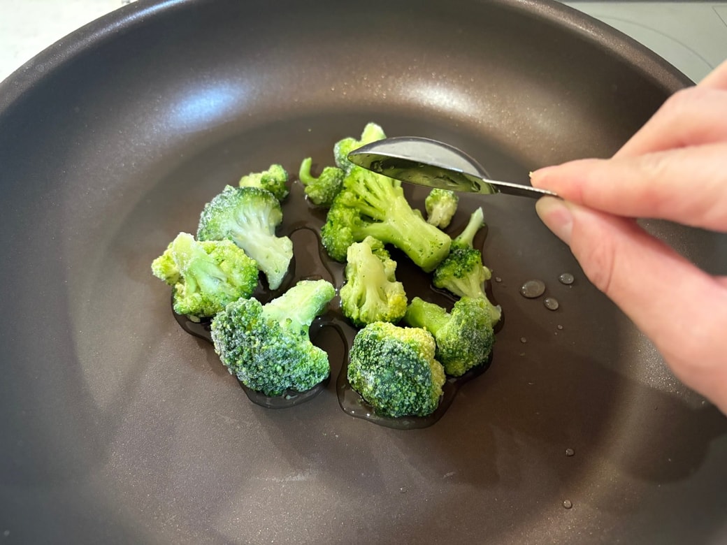 フライパンに冷凍ブロッコリーと水を入れる