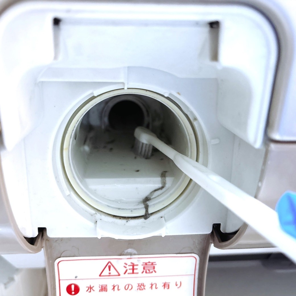 差し込み口の汚れを歯ブラシでかき出す