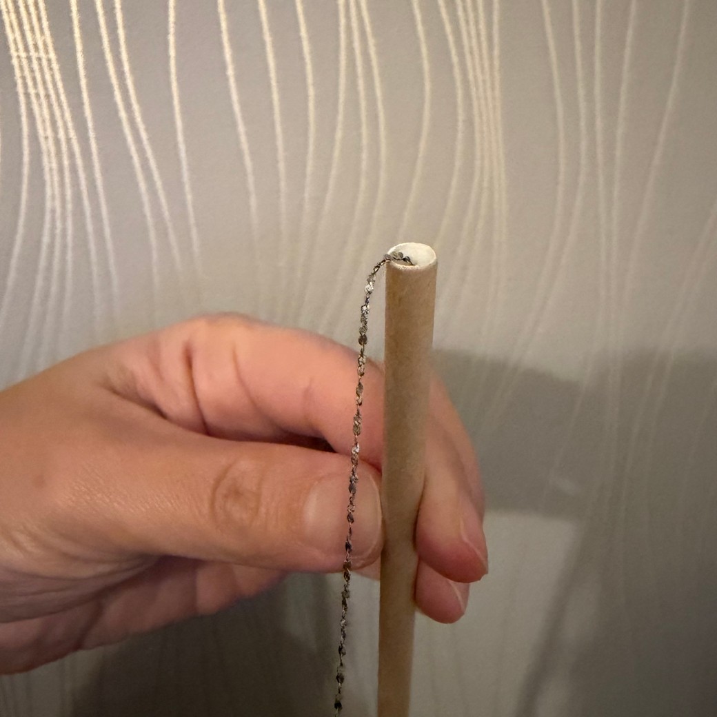 ネックレスをストローの中に入れているところ