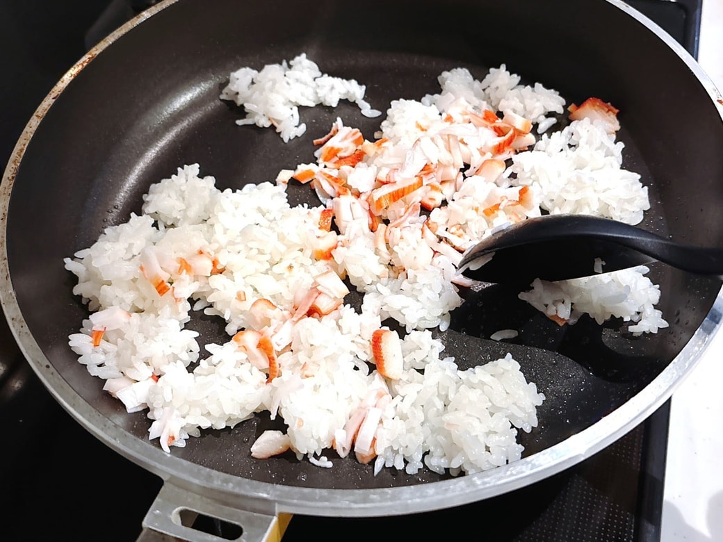 フライパに油をひき、ごはんとカニカマを炒める