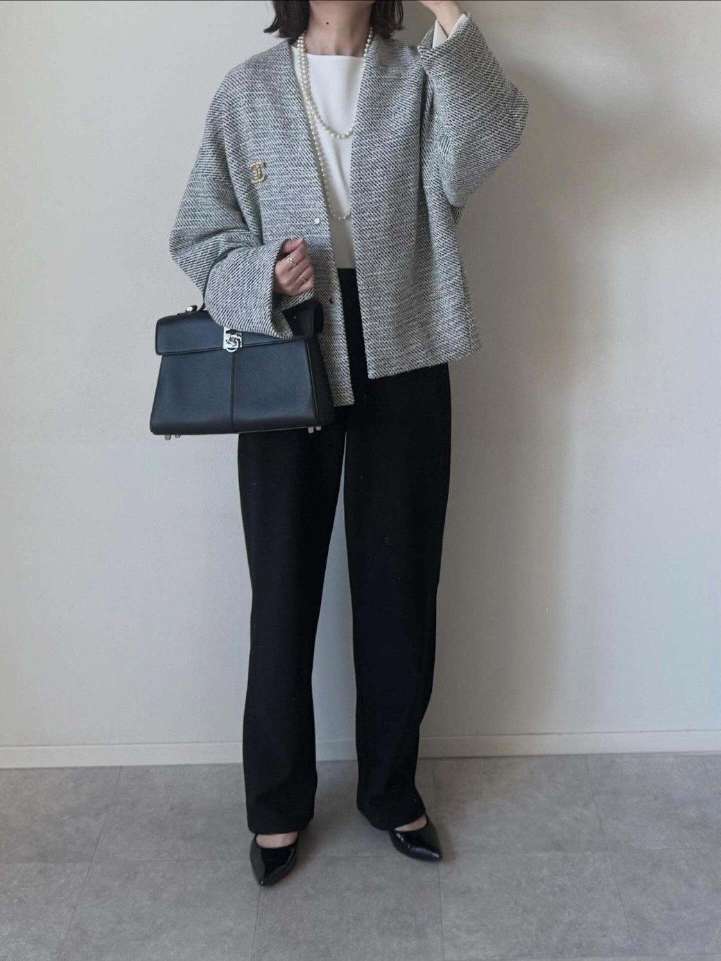 華やかなツイードジャケットを黒のパンツで引き締めて。