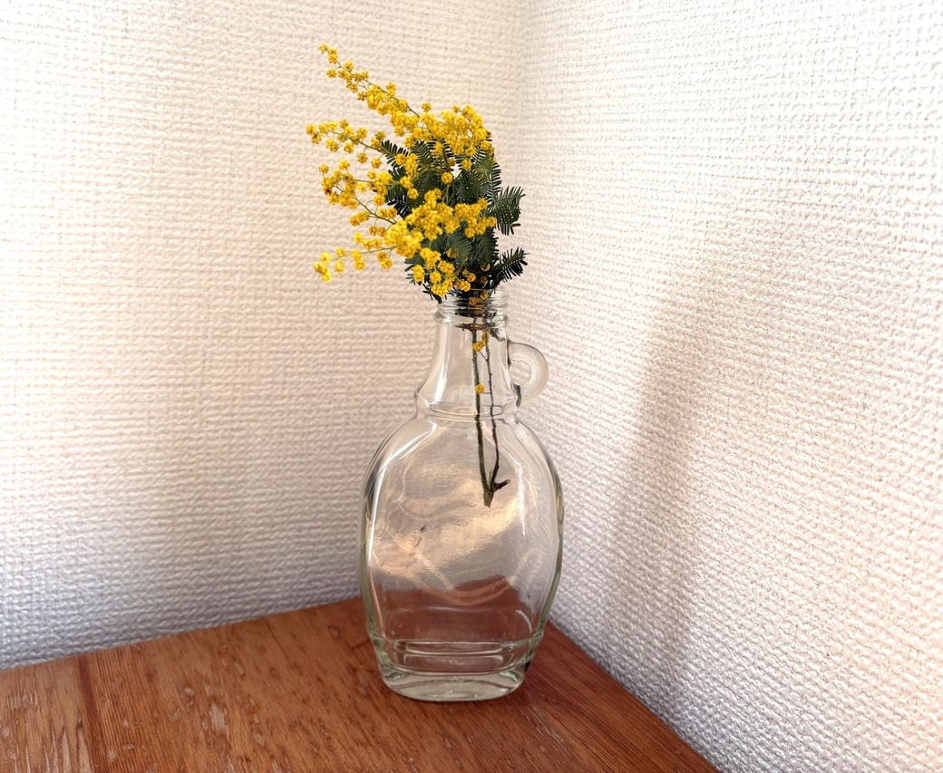シンプルなガラス瓶に。ミモザのドライフラワーを瓶にさした様子