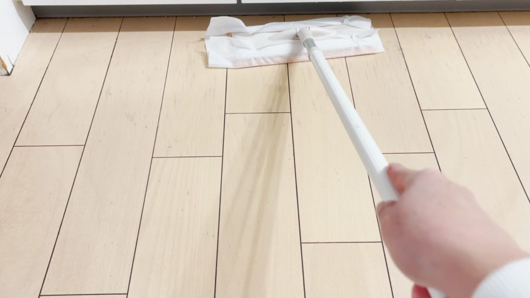 床をフロアワイパーで拭く