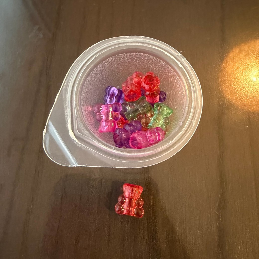 ミニゼリーの空き容器にビーズを入れているところ