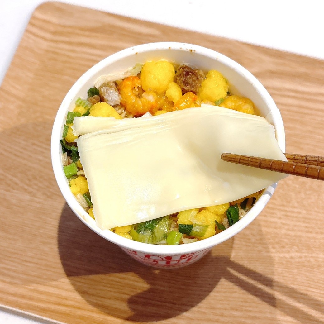 カップヌードルにスライスチーズをのせる