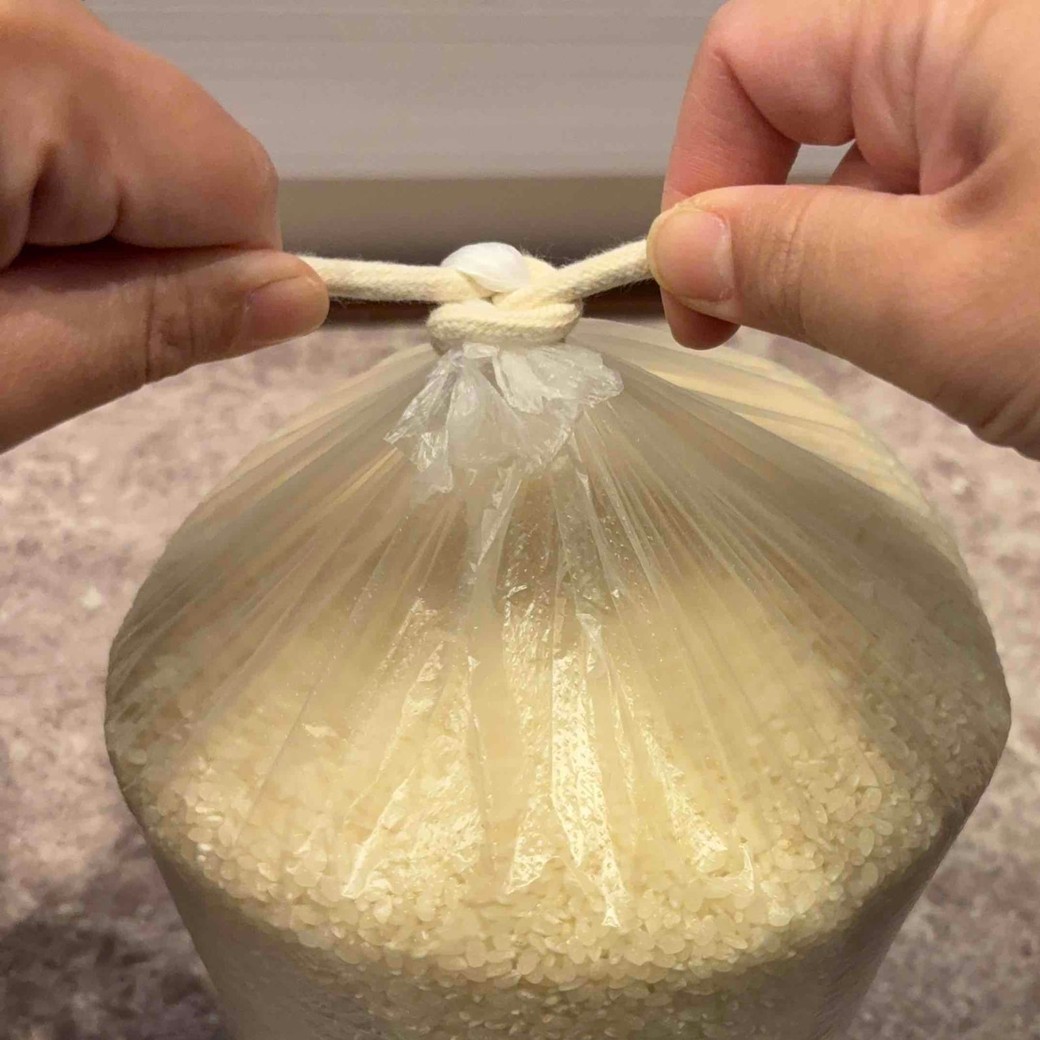 紐を両手に持って横に引っ張っているところ