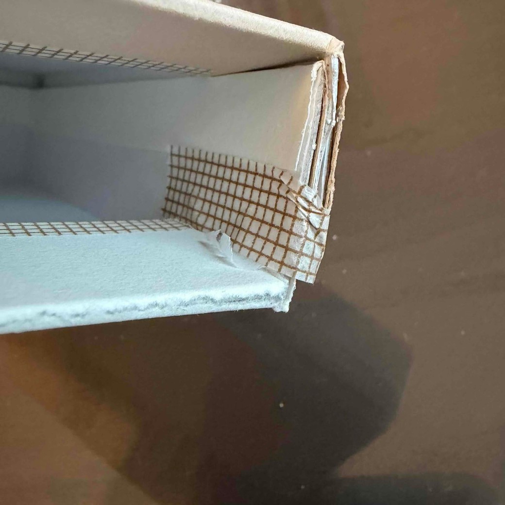 マスキングテープで箱をとめているところ