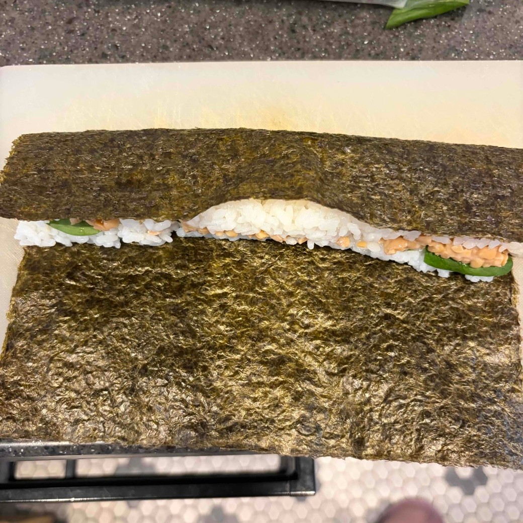 のりでごはんを巻いているところ