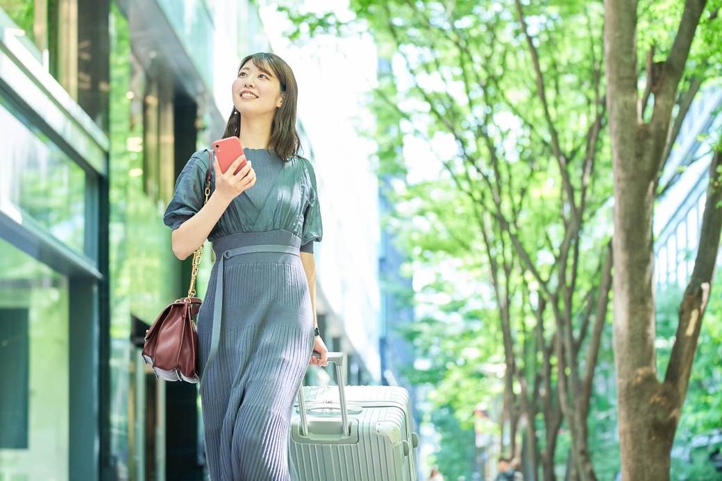 スーツケースを持って歩く女性