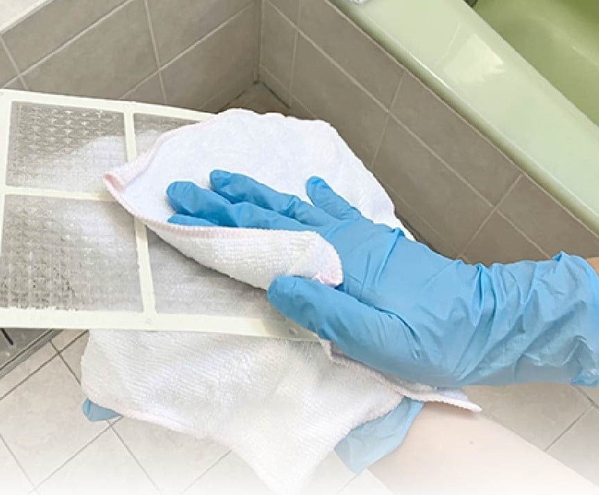 浴室乾燥機を掃除する人