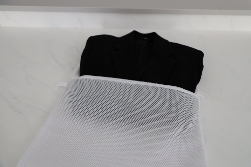 スーツを畳んで洗濯ネットに入れる