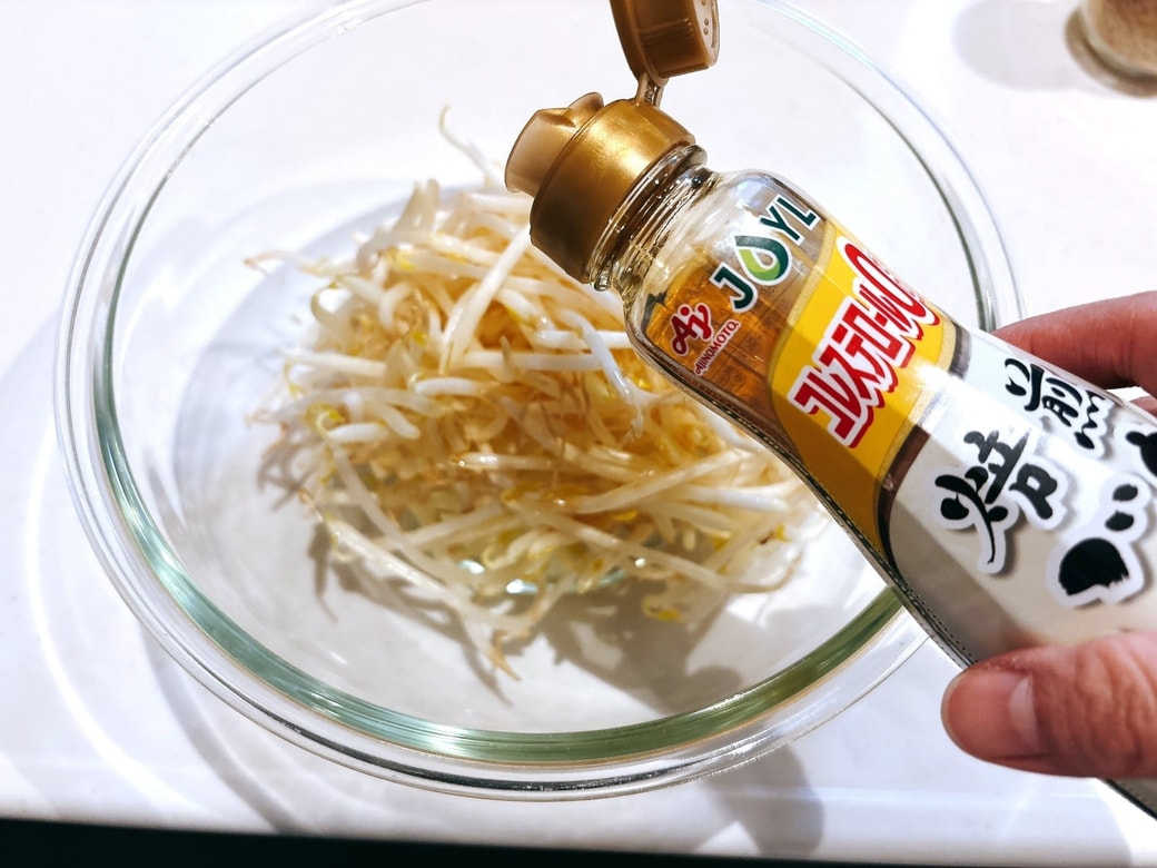 もやしにごま油を加える