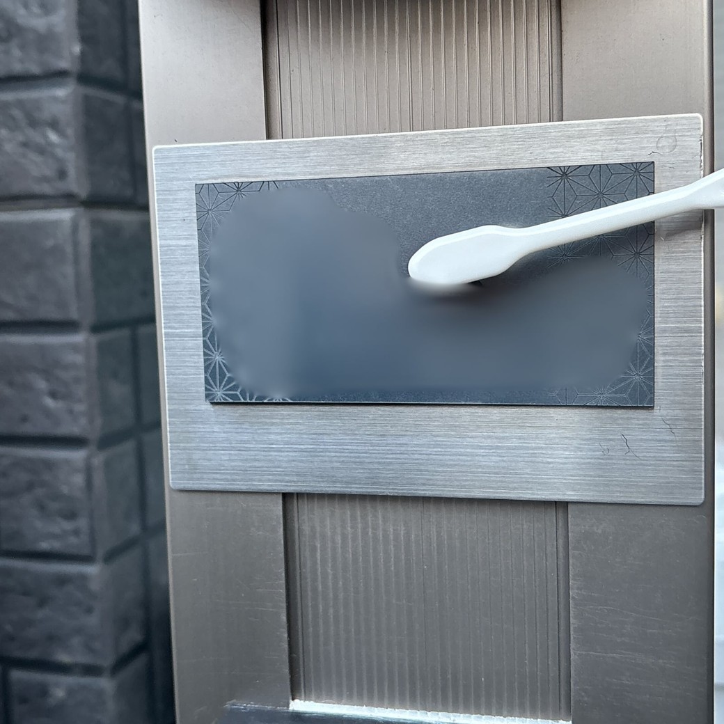 歯ブラシで表札の汚れを落とす