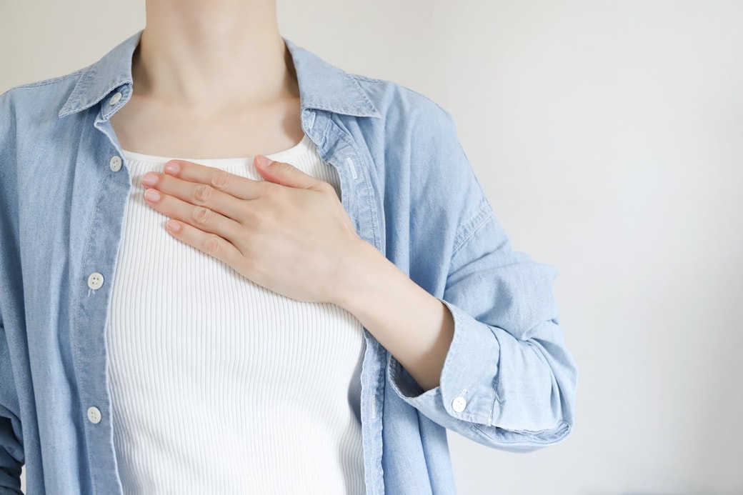 胸に手を当てる女性