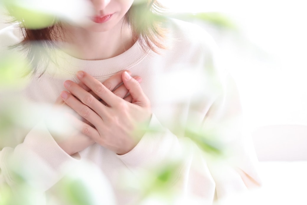 胸に手を当てる女性