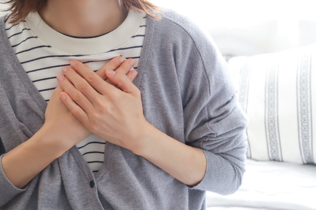胸に手を当てる女性