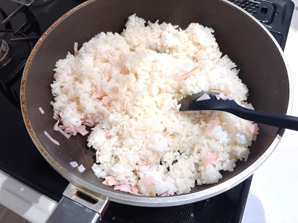 中火でハムとごはんを炒める