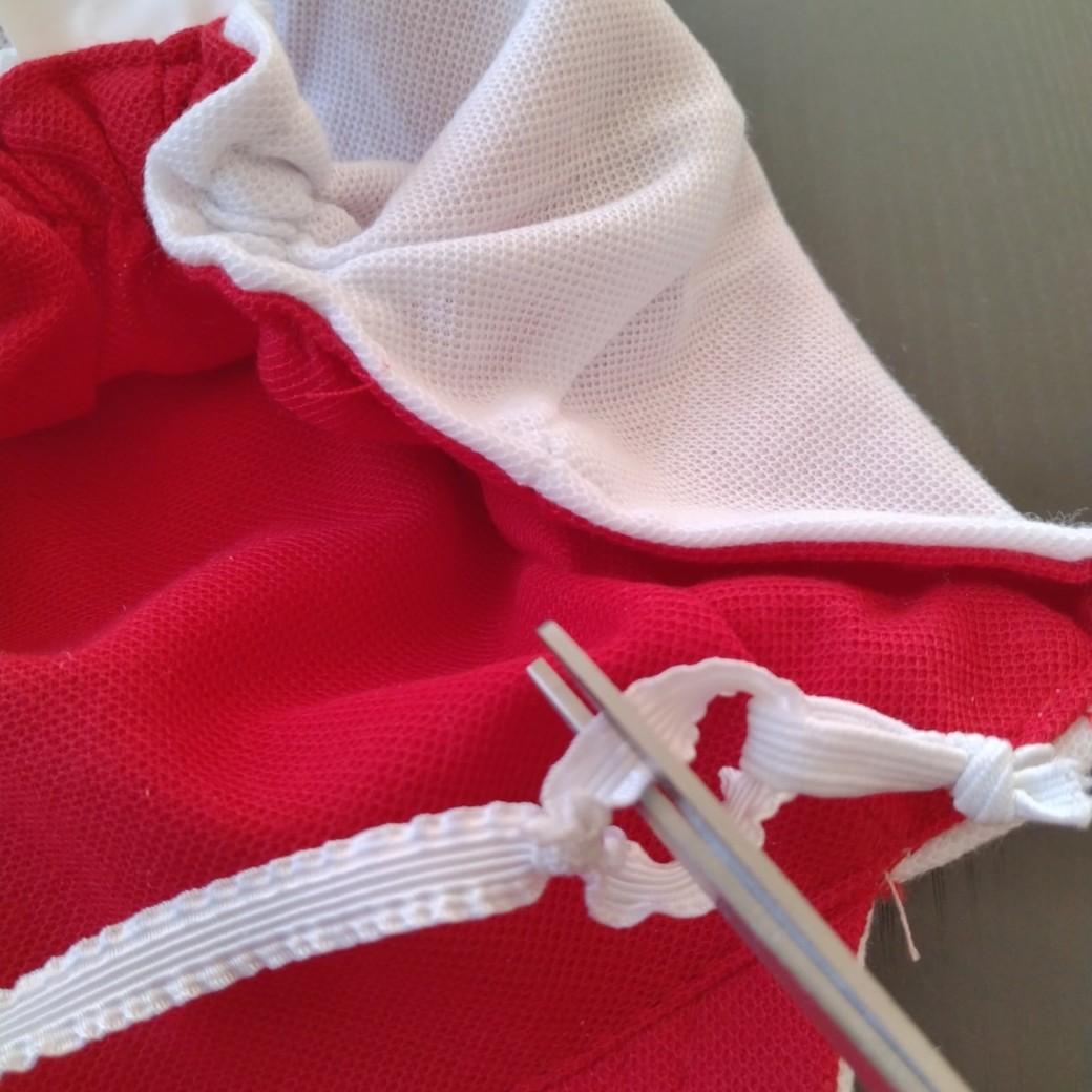 帽子のゴムを切る人