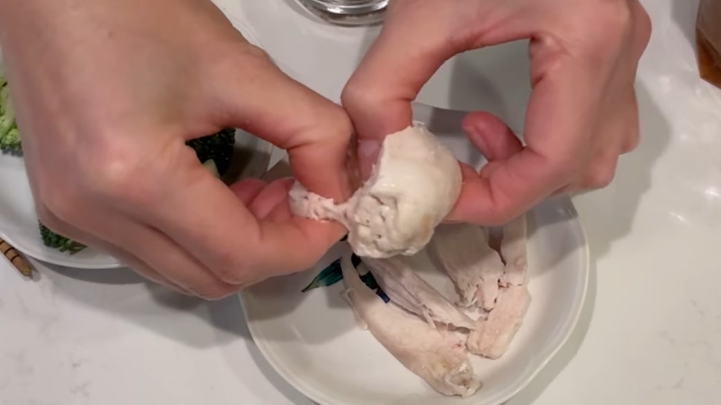 蒸し鶏を手でちぎる人