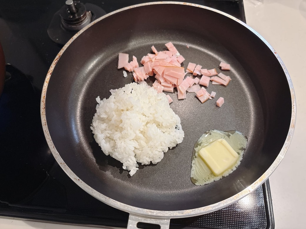 フライパンをバターに入れて熱し、ハム・ごはんを炒める