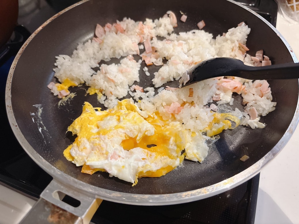 ごはんを端に寄せて、卵を割り入れる