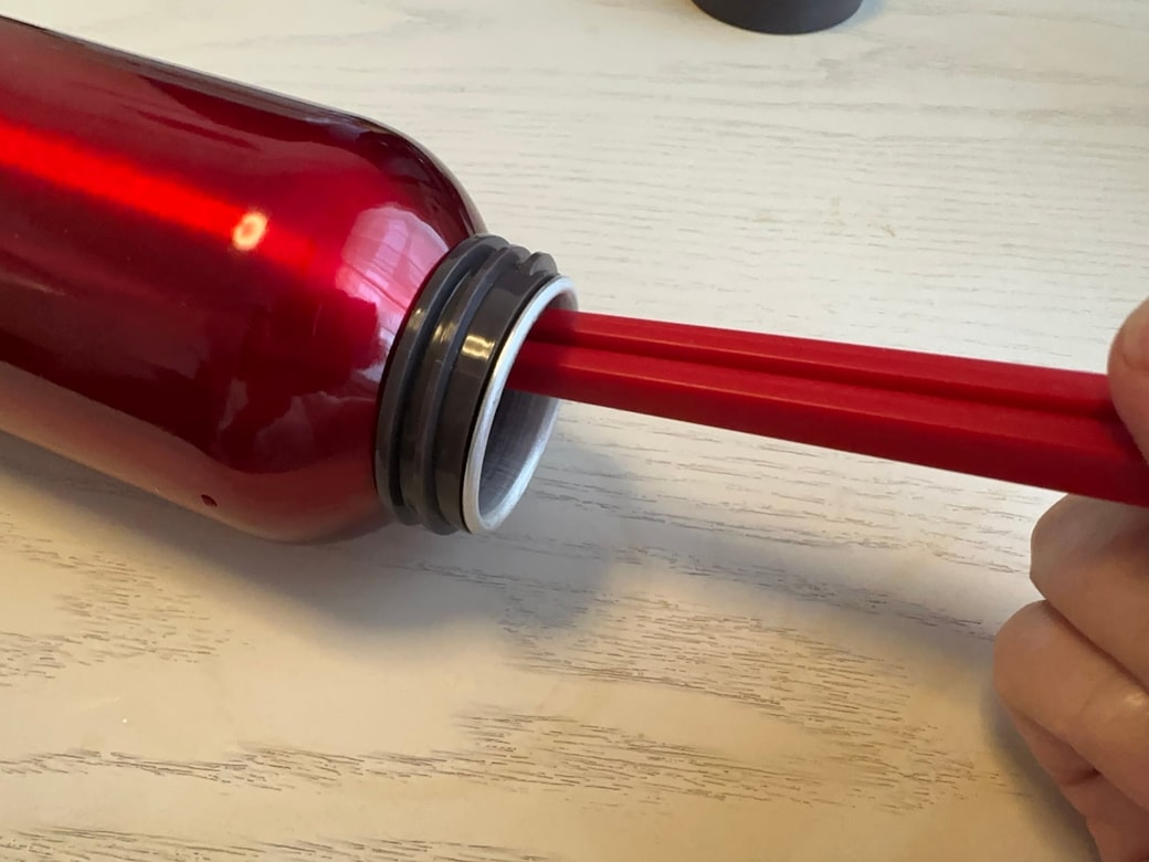 水切りネットをつけた菜箸でボトルを洗う