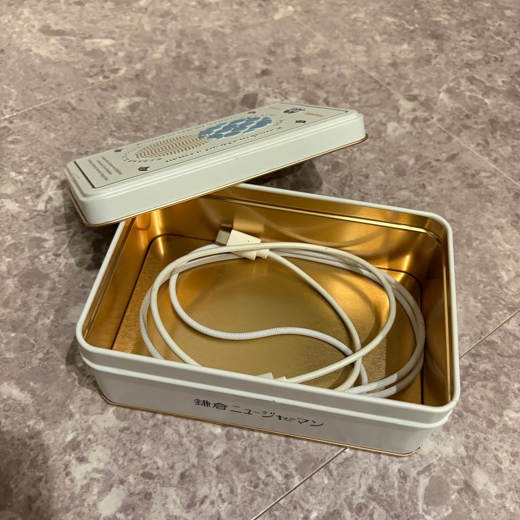 缶にスマホコードを入れているところ