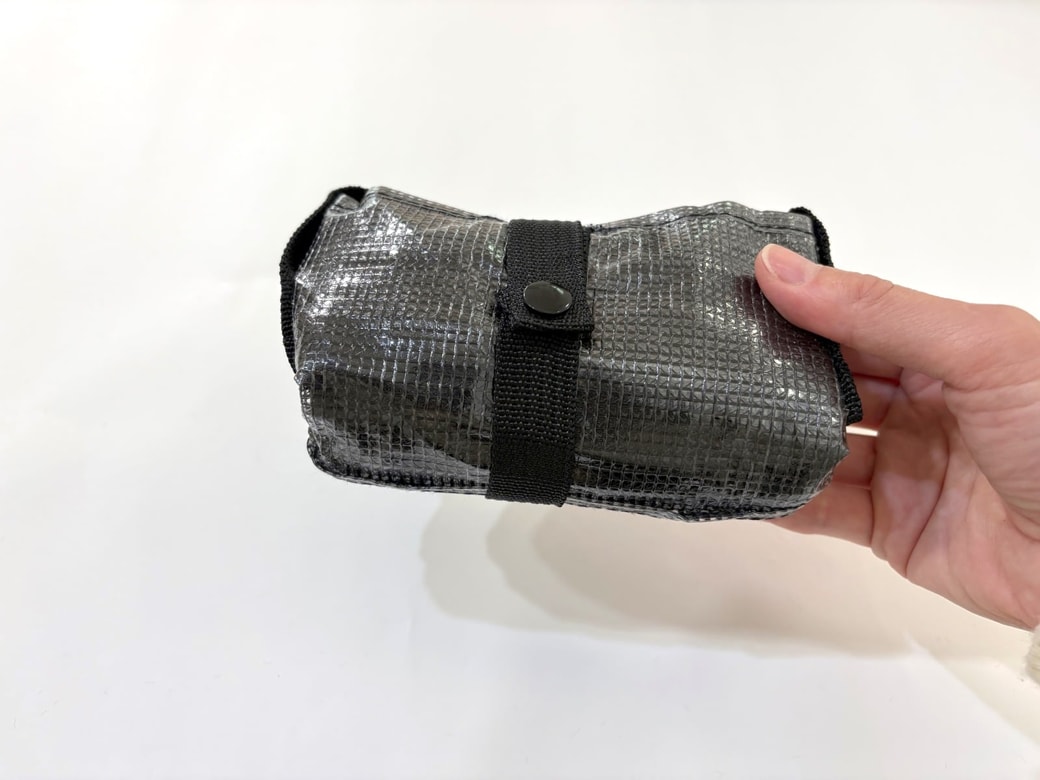 まるめてベルトのボタンを留めるとコンパクトになる