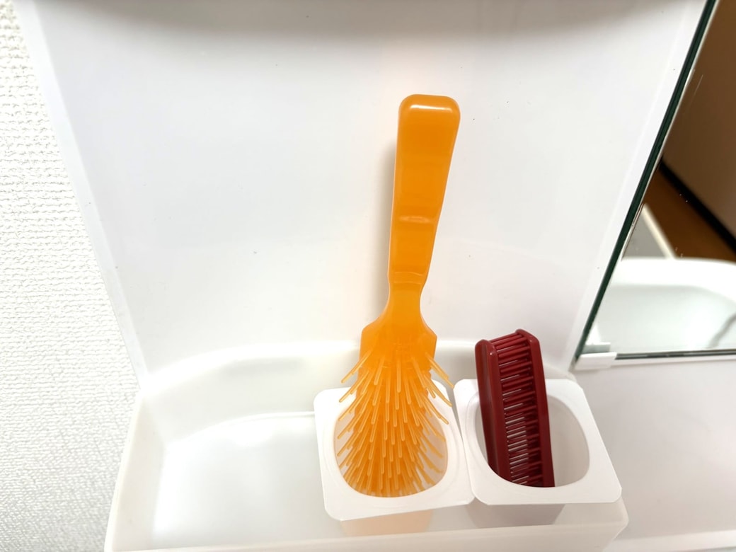 空き容器にヘアブラシを立てた様子