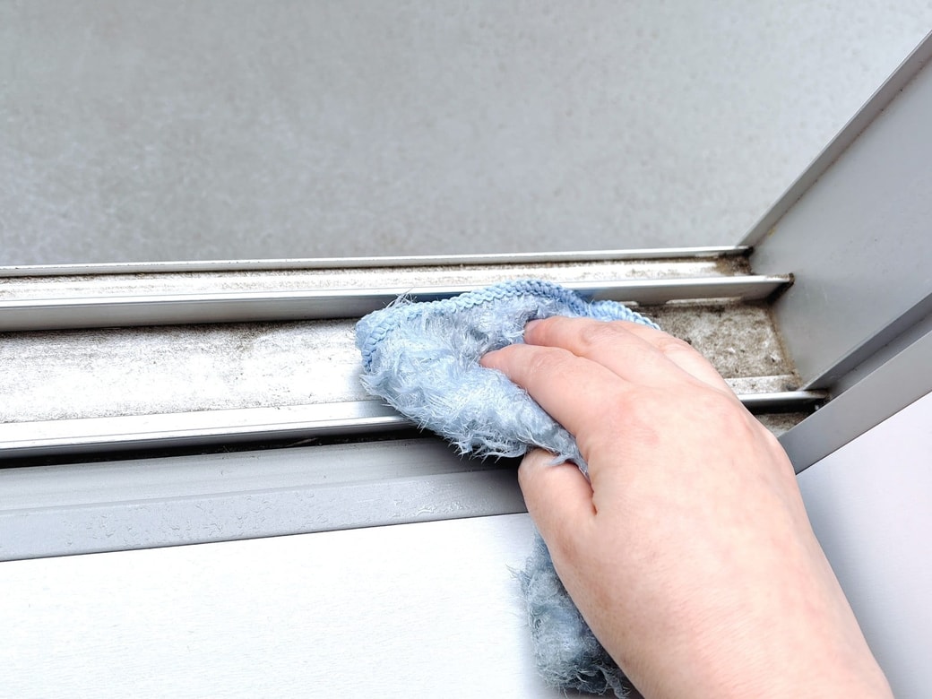 窓サッシの汚れを拭き取る