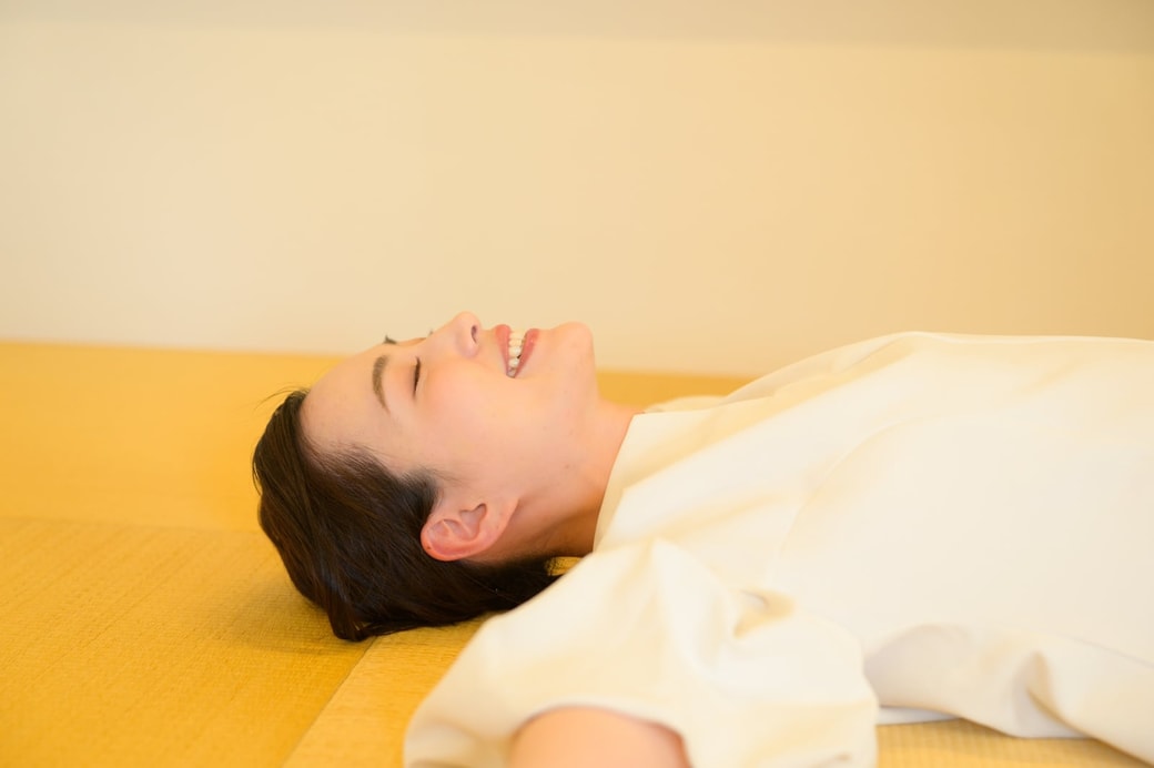 寝転んでストレッチをする女性