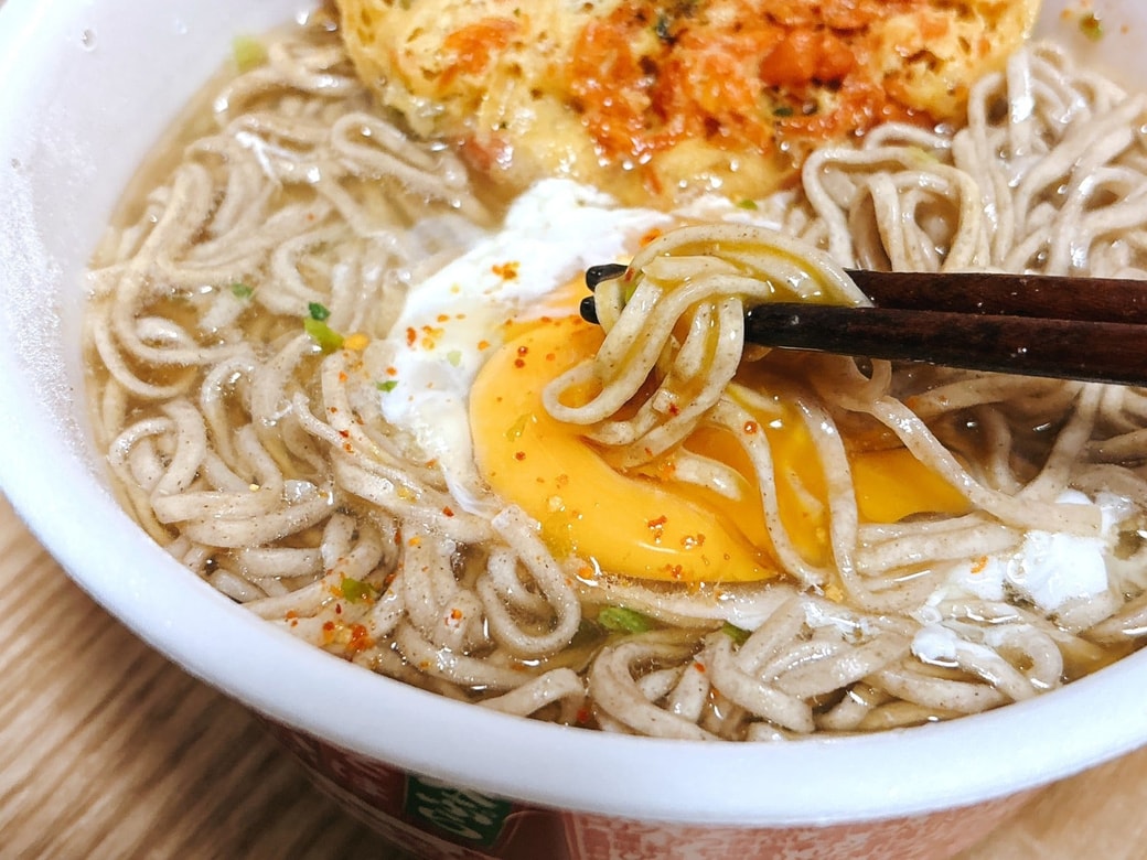 黄身にそばを絡める