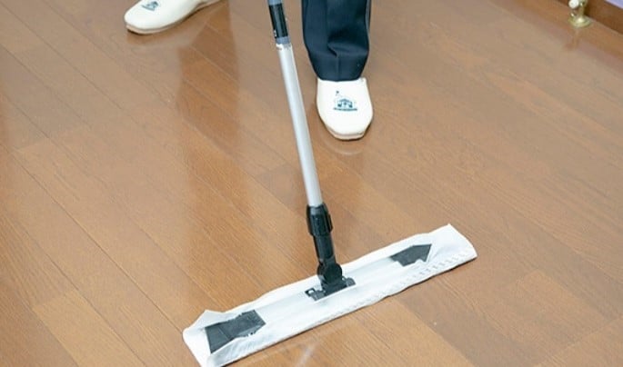 フロアーワイパーで掃除する人　