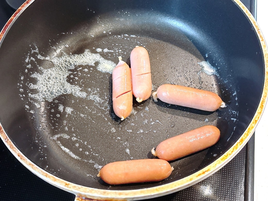フライパンにバターを熱してウインナーを炒める
