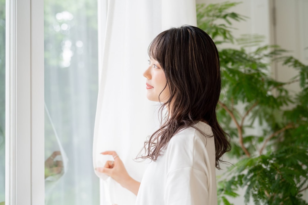 窓の外を眺める女性
