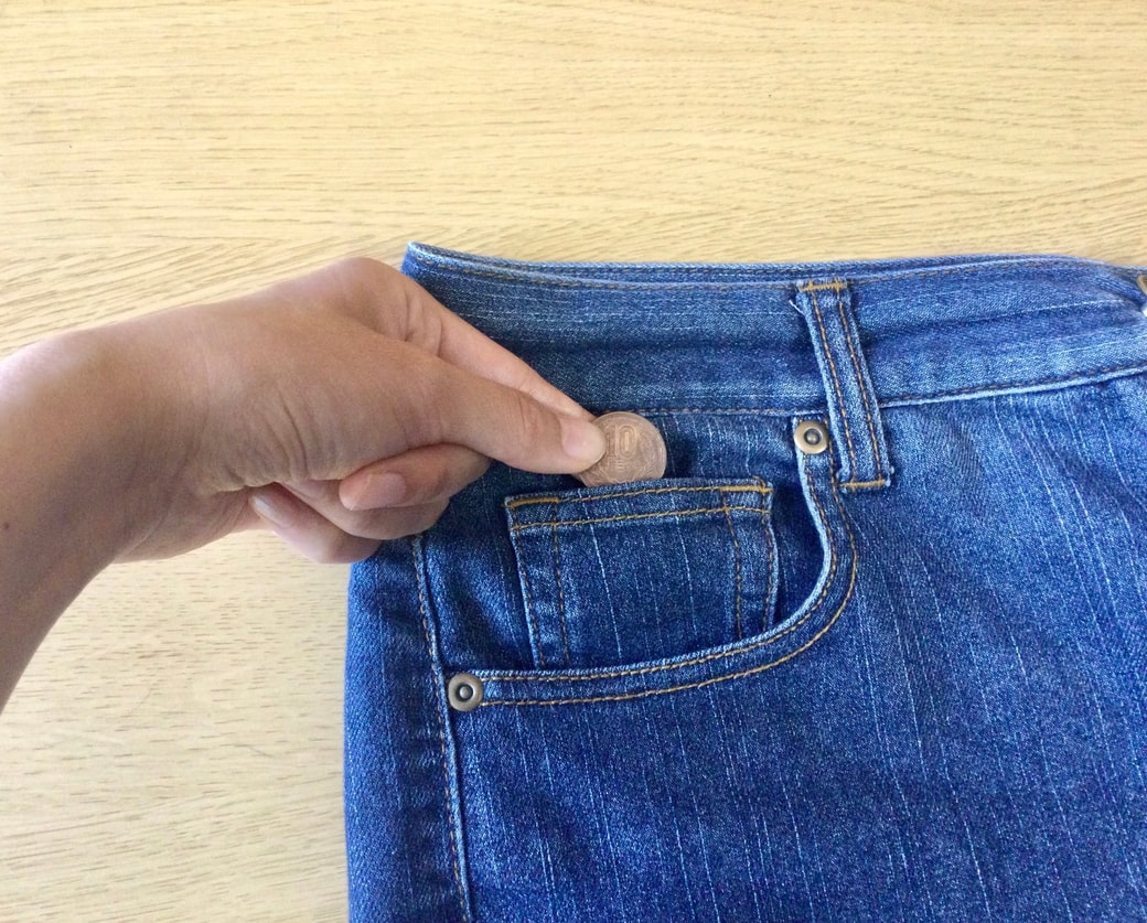 ジーンズのポケットに小銭を入れる