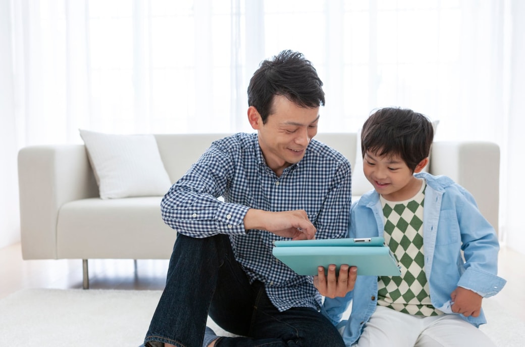 タブレットを見る親子