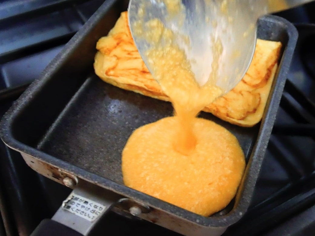 手前のスペースに卵液を注いで焼く。