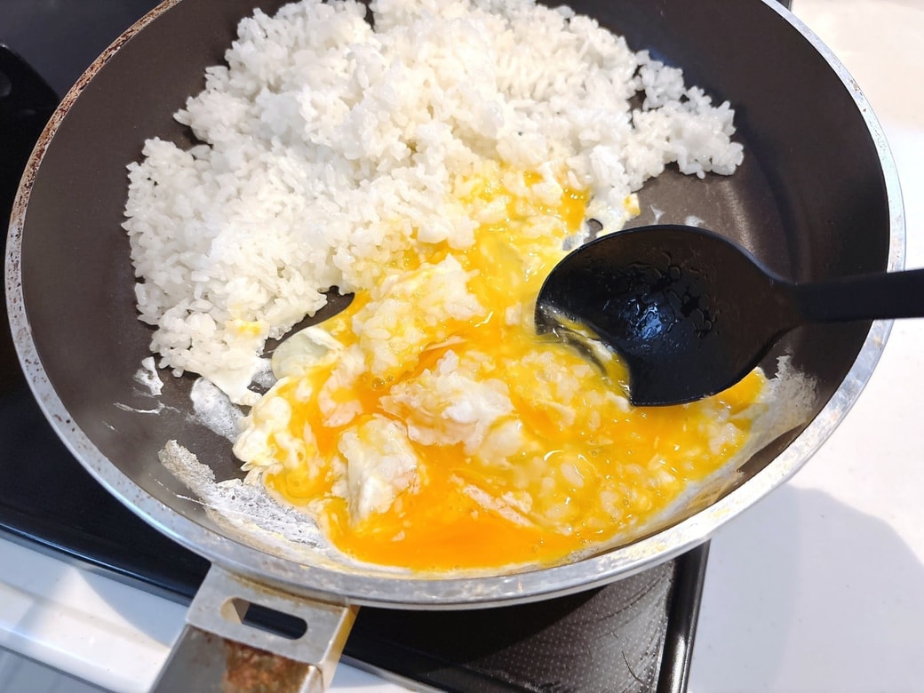フライパンの端にごはんを寄せて、卵を炒める
