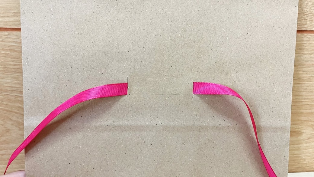 縦の切り込みにリボンを通した様子
