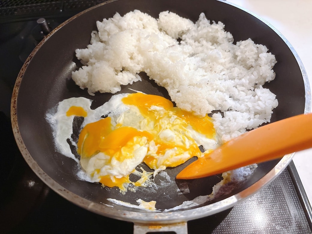 ごはんを寄せてあけたスペースに卵を入れる