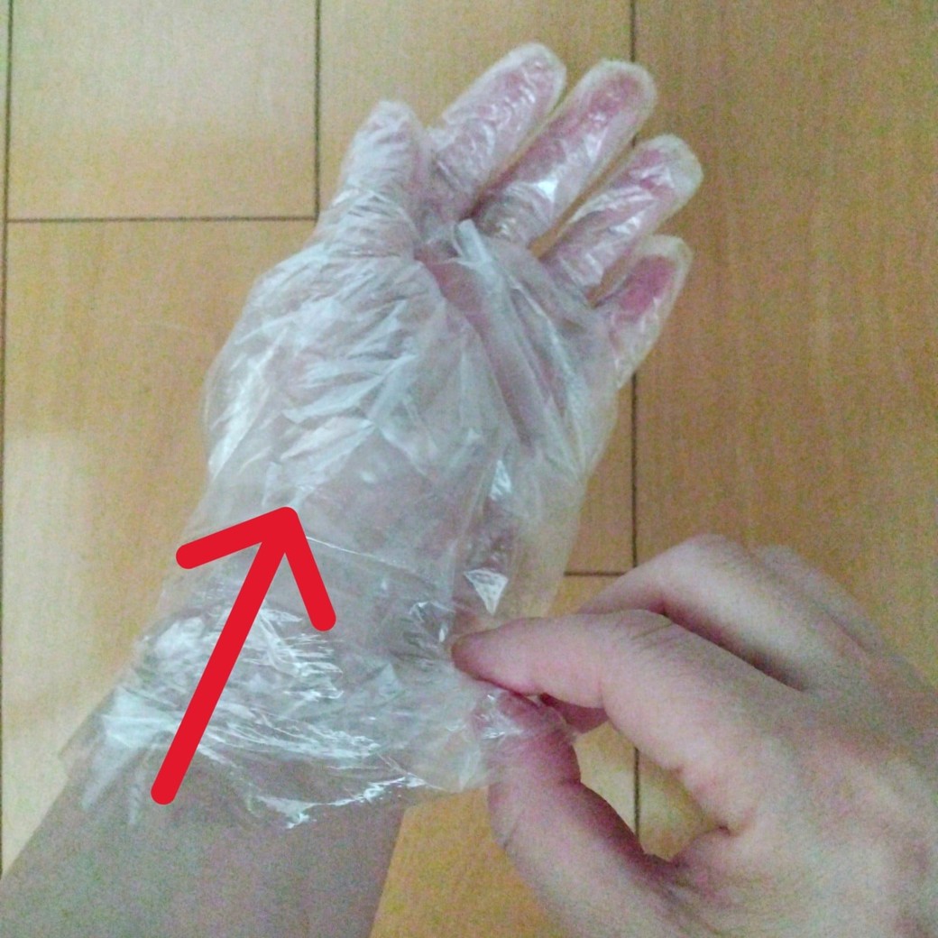 ビニール手袋をはめた左手