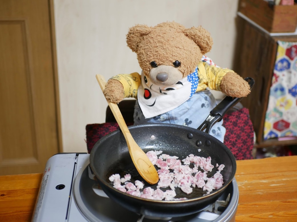 豚肉を炒めるくまくん